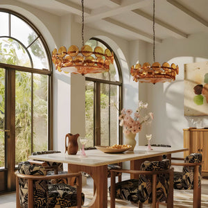 Sunny dining room with large arched windows, a white table, patterned chairs, two Italian Retro Pendant Lights, a vase of flowers, and glassware set on the table.