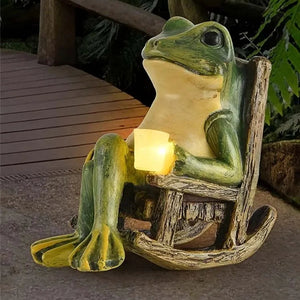The Solar-powered Rocking Chair Frog Light features a charming frog figurine seated in a wooden rocking chair holding a small glowing lantern, making it the perfect garden frog ornament for your outdoor space.