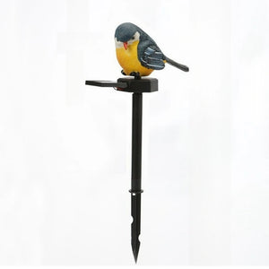 A Solar Bird Light perched atop a black garden stake, showcased against a plain white background.