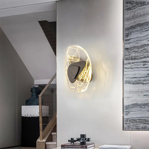 Luxury Crystal Wall Lamp featuring glowing lines, mounted on a light-colored wall near stairs and a decorative sculpture in a contemporary interior.