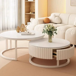 The Luxury Round Coffee Table Set, featuring a minimalist table with a ribbed drawer partially open, is placed in a modern living room with a white sofa and stylish decorative items on the tables.