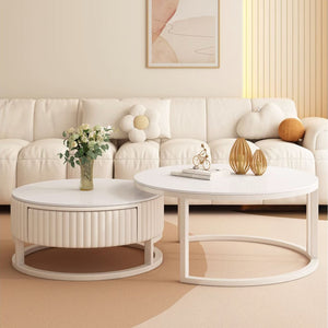 A modern living room with a cream-colored sofa, the Luxury Round Coffee Table Set, decorative vases, a flower bouquet, and abstract wall art.