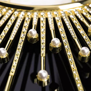 Close-up of the Premium Sun Wall Clock: gold rods with crystals and pearls radiate on a glossy black face, creating an elegant sunray-inspired design.