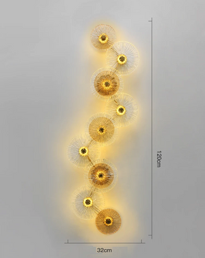 The Amber Deco Wall Sconce features ten vertically arranged circular glass discs and emits a warm yellow glow; it measures 120 cm in height and 32 cm in width.