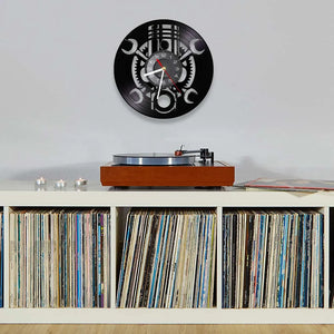 A Black Record Wall Clock hangs above a shelf filled with records, while a record player sits on top.