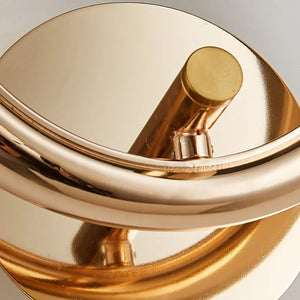 Close-up view of an Elegant Ring Wall Sconce, featuring a shiny gold finish with sleek curves and a cylindrical design, adorned with faceted crystals.