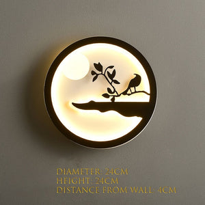 The Minimalist Wall Lamp features a bird-on-branch silhouette, emitting a soft and warm glow. Its dimensions are 24cm in diameter, 24cm in height, and extends 4cm from the wall, ideal for any modern home.