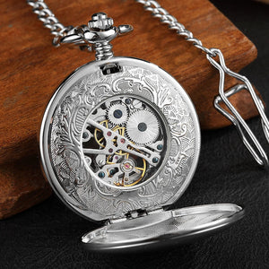 The Vintage Mechanical Pocket Watch features an open ornate cover, revealing exposed gears and mechanical parts. It rests on a wooden surface with a metal chain attached.