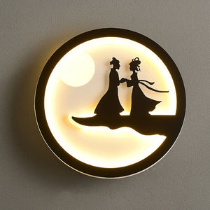 Silhouettes of two people in traditional attire stand hand in hand under a glowing full moon within a circular frame, emanating a gentle and cozy radiance similar to the Minimalist Wall Lamp found in contemporary homes.
