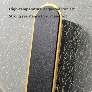 Close-up of the Beautiful Wall Sconce, an iron art piece with a high-temperature lacquered black matte finish and elegant gold edges. The background showcases a pattern of gold lines, embodying contemporary and minimalist design. Text reads: "High-temperature lacquered iron art. Strong resistance to rust and rot.