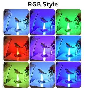 A side table featuring the Bird Table Night Light, reflecting elegant craftsmanship, is displayed in nine different RGB light colors: red, blue, green, purple, turquoise, and white. A vase with roses is placed next to the lamp in each image.