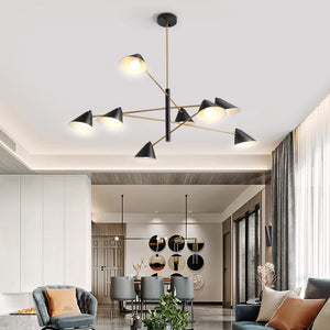 A modern living room showcases a Multi-Arm Ceiling Light in black and gold, paired with gray furniture and round wall mirrors. Sheer-draped large windows let natural light amplify the elegant ambiance.