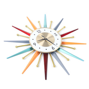 The Sunburst Wall Clock features a white face with black hands and numbers, highlighted by vibrant multicolored rays and gold accents in a bold mid-century starburst design.