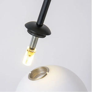 The Minimalist Line Light features a black lamp socket with a glowing LED bulb hovering above a white lampshade with a visible circular hole, embodying modern sculptural lighting aesthetics and seamlessly blending form and function for sleek minimalism.
