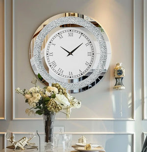 The Modern Luxury Roman Numerals Wall Clock hangs above a table with a vase of flowers and decorative accents in an elegant, light-colored room.