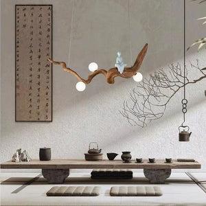 Minimalist decor with a Zen-Inspired Wooden Pendant Light, a tea set on the table, cushions, and a calligraphy scroll on the wall—all combine to create a serene zen aesthetic.