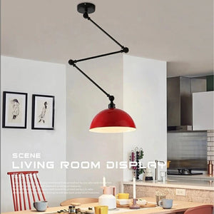 A modern kitchen features a Zig Zag Pendant Light with a red dome hanging over a wooden table set with cups and plates. Abstract art on the wall adds an industrial design charm, while a small stack of books rests on the counter.