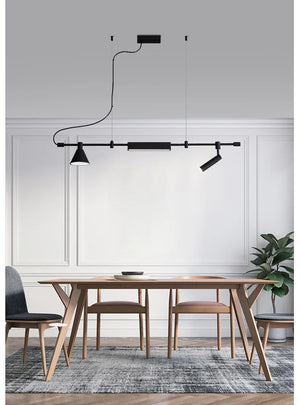 Modern dining area featuring a wooden table and chairs, a patterned rug, and Modern Track Lighting set against a paneled white wall.