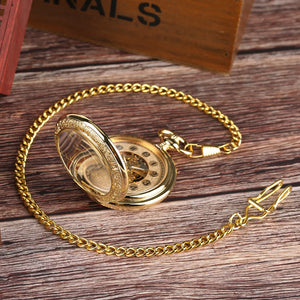 The Premium Golden Pocket Watch, featuring a skeleton dial and golden chain, rests elegantly on a wooden surface, showcasing its intricate clock face.