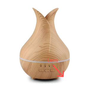 Air Humidifier SpyCam: This light wood-grain essential oil diffuser features buttons labeled ON, 1H, and 3H, plus a clearly marked “Lens” area at the base (with a red arrow). It blends discreetly into any décor, providing soothing aromatherapy alongside covert recording capabilities.
