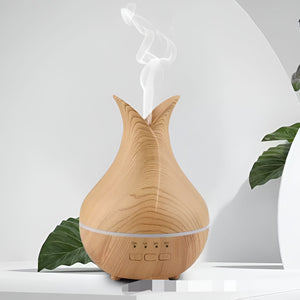 The Air Humidifier SpyCam, featuring a wooden texture, discreetly operates as both an essential oil diffuser and a hidden camera, emitting a gentle stream of mist while resting on a white surface with green leaves partly visible in the background.