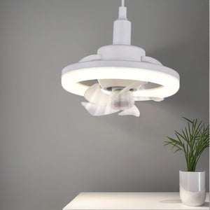 The 360° Rotatable Fan Light, mounted on a gray wall above a white table with a small plant, provides ambient lighting and optimal air circulation.