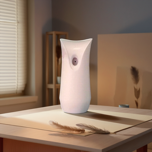 A White Decorative Display SpyCam blends seamlessly into its softly lit surroundings on a wooden table, resembling a vase. Perfect for a discreet 007 operation, the feathers and shadows add to its mystique.