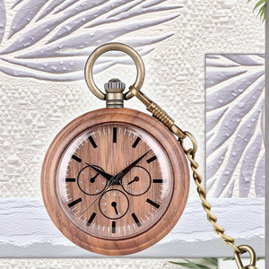 The Handmade Wood Pocket Watch, featuring black markings, three subdials, and a brass chain, is displayed against a textured pattern.