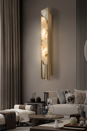The Luxury Marble Wall Sconce features a tall, rectangular design that emits a warm glow, perfect for enhancing modern living rooms with neutral tones, floor-length curtains, and contemporary furniture.