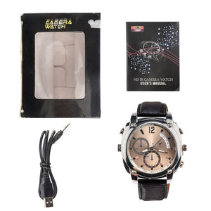 The Wristwatch SpyCam, featuring 1080P video, a brown leather strap, USB charging cable, black retail box, and user manual, is displayed on a white background.