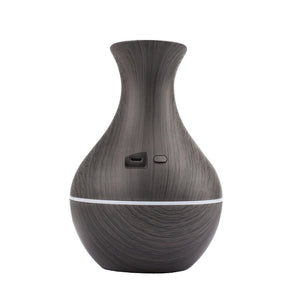 The Black Decorative Display SpyCam, a dark wood grain vase-shaped diffuser with a front button and USB port, seamlessly merges home décor aesthetics with advanced espionage technology.