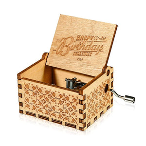 The Happy Birthday Music Box is a delightful small wooden music box featuring intricate designs. It has an open lid that displays "Happy Birthday Dear Sweet" and a convenient hand-crank mechanism on the side. This charming, hand-cranked music box adds a nostalgic touch to any celebration.