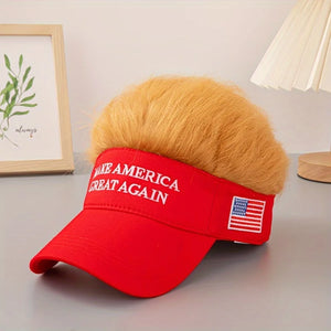 A Visor Cap - Make America Great Again, featuring attached fake blond hair, sits on a gray table next to a lamp and framed wall art.