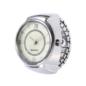 The Eternal Ring Watch is a silver ring with a small analog quartz clock face, Roman numerals, and a metal stretch band—ideal for those who love unique jewelry watches.
