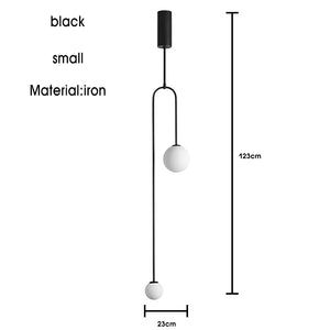 The Minimalist Line Light is a black, small iron pendant featuring two round white bulbs. It exemplifies modern lighting with its sleek design, standing at 123 cm tall and 23 cm wide, and incorporates a minimal mounting system.