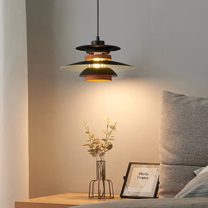 A Scandinavian-style bedroom with a bed and a pendant light hanging above it.