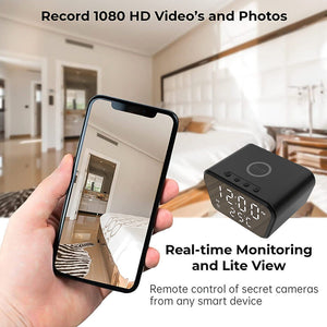 A hand holding a smartphone displaying a bedroom interior, alongside an image of a Clock Charger SpyCam device with text highlighting its discreet monitoring, real-time monitoring, and remote control capabilities, including iPhone & Android