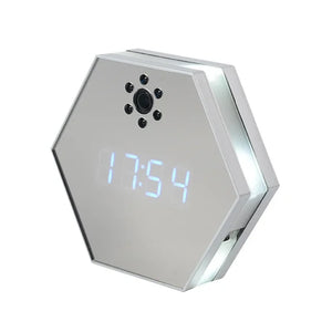 The Sleek Clock SpyCam features a hexagonal LED display, mirrored surface, and hidden spy camera lens on its face, surrounded by infrared night vision sensors.