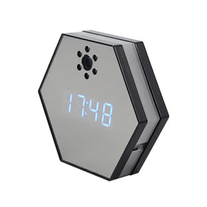 The Sleek Clock SpyCam is a hexagonal digital clock with a blue LED display at 17:48, featuring a hidden 4K HD spy camera, speaker holes, and a discreet lens above the screen.