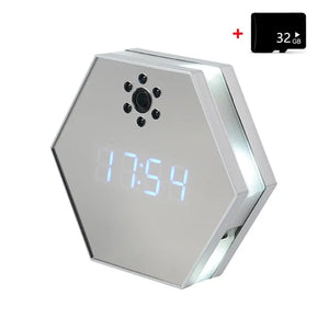 The Sleek Clock SpyCam is a hexagonal digital clock with a mirrored face, built-in spy camera with multiple lens holes, 4K HD resolution, and comes with a 32GB microSD card. The display shows the time "17:54.