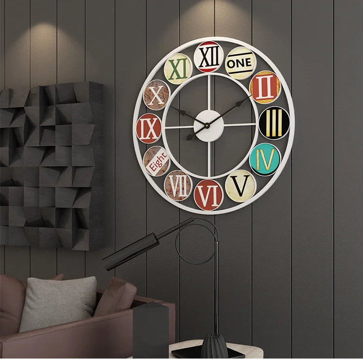 The Nordic Color-Ring Wall Clock, featuring mixed styles and vibrant colors for each number, hangs on a dark paneled wall above a sofa and beside a black floor lamp.