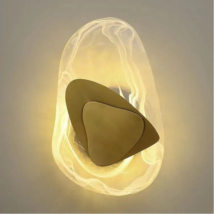 The Luxury Crystal Wall Lamp features layered, smooth, irregular shapes in gold and white, emitting a soft glow against a neutral background for an abstract and luxurious effect.