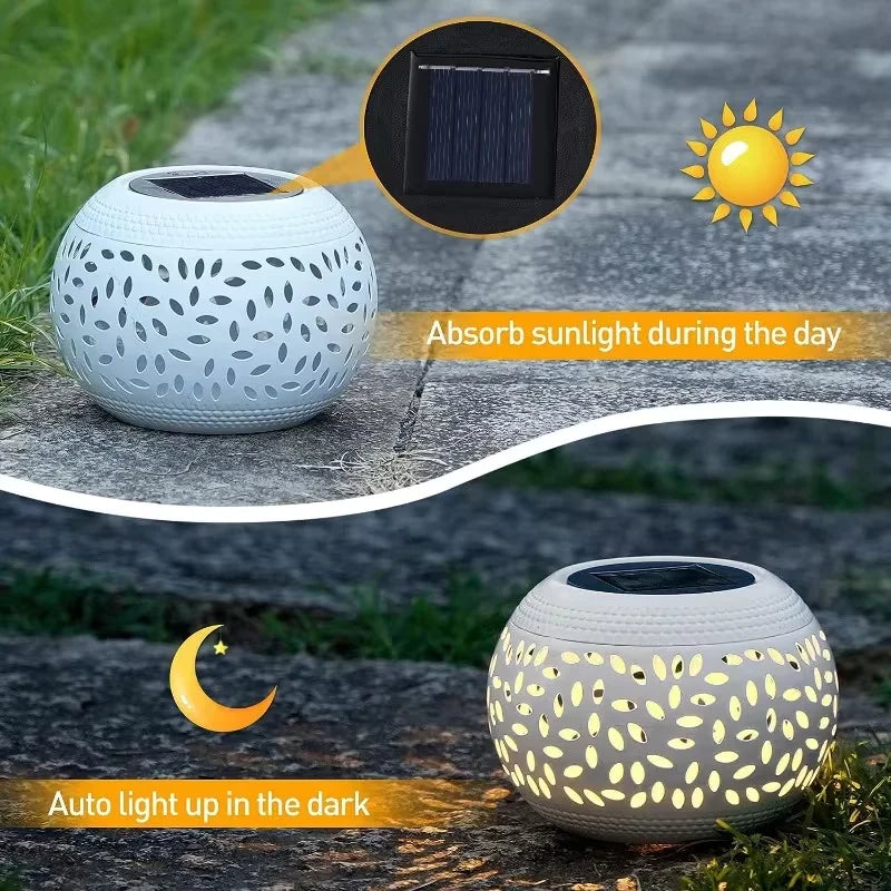The Solar Orb Lamp, with its round white design, absorbs sunlight throughout the day and casts a patterned glow at night when placed along a stone path.