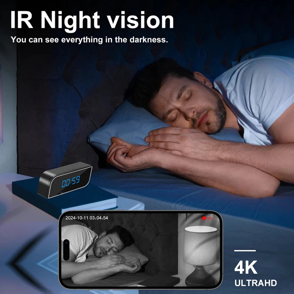 A man sleeps in bed beside a digital clock; his phone displays an IR night vision feed from the SpyCam Camera Clock with motion detection, capturing the black-and-white scene.