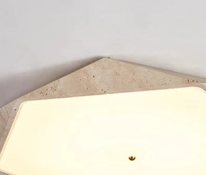 A rectangular off-white sink with a central drain is set into a light-colored, textured stone countertop against a plain white wall, softly illuminated by the Natural Stone Ceiling Light, which enhances the serene and understated aesthetic of the space.
