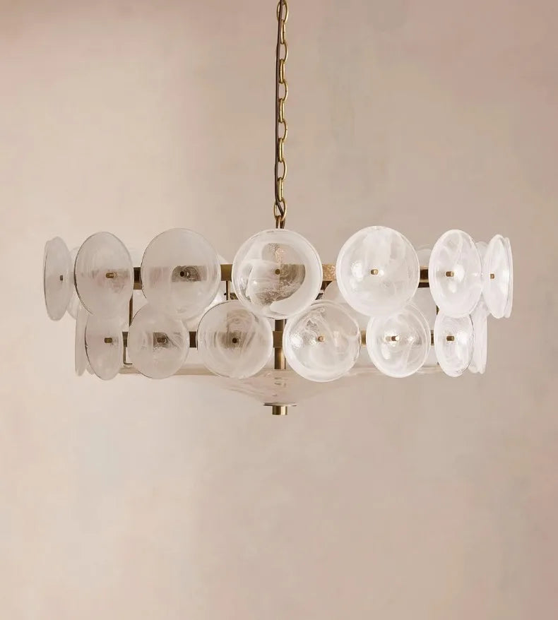The Italian Retro Pendant Light features circular, translucent glass discs arranged around a brass frame and suspended by a chain, bringing the timeless elegance of Mid-Century Modern Italian artisan lighting to any space.