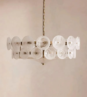 The Italian Retro Pendant Light features circular, translucent glass discs arranged around a brass frame and suspended by a chain, bringing the timeless elegance of Mid-Century Modern Italian artisan lighting to any space.