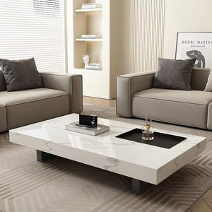A modern living room with two grey sofas, neutral decor, and the Modern Luxe Coffee Table in white marble, styled with books, a framed print, and cushions.