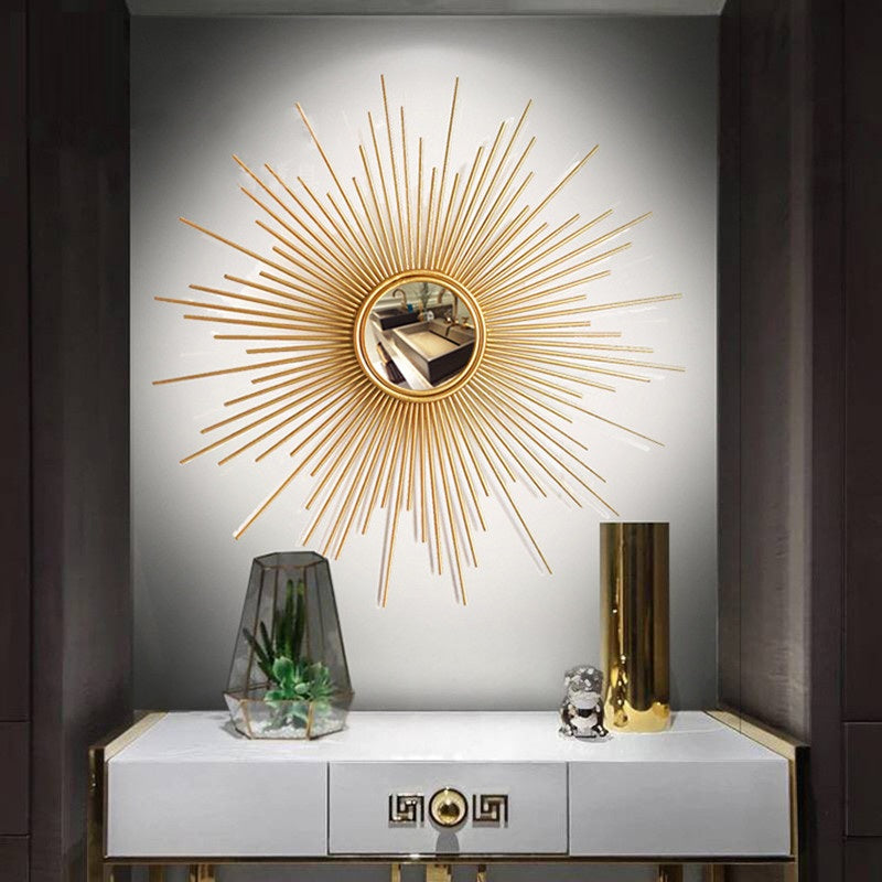 The Luxe Sunray Wall Mirror hangs above a white console table with two drawers, adorned with a glass terrarium, gold vase, and small sculpture—bringing statement interior design to life.