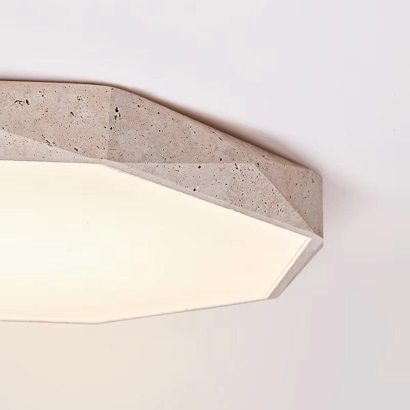 The Natural Stone Ceiling Light features a geometric, stone-textured design with faceted edges reminiscent of wabi-sabi lighting. Mounted on a white ceiling, it emits a soft, inviting glow.